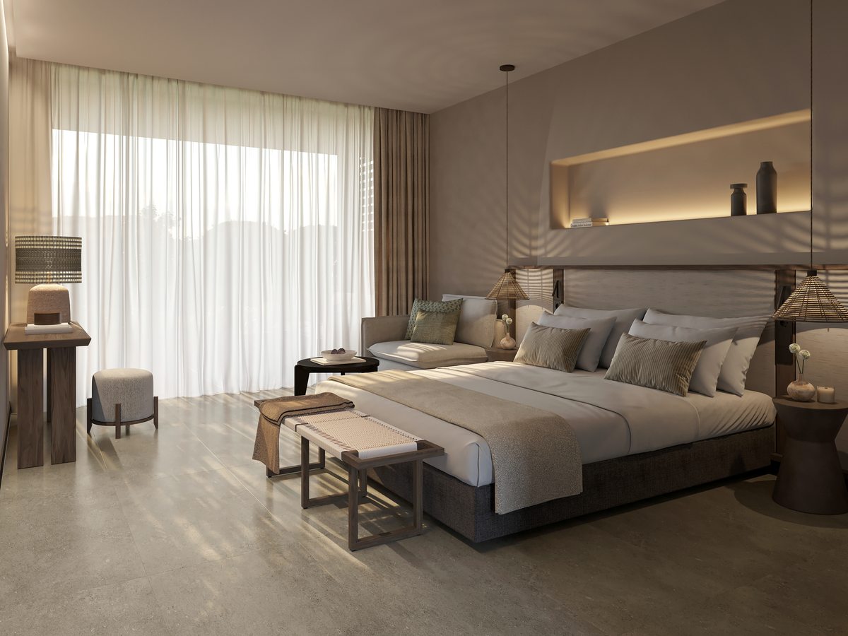 A Double Room at Ikos Kissamos, with a king bed, a bench at its foot and a curtained full-height window.