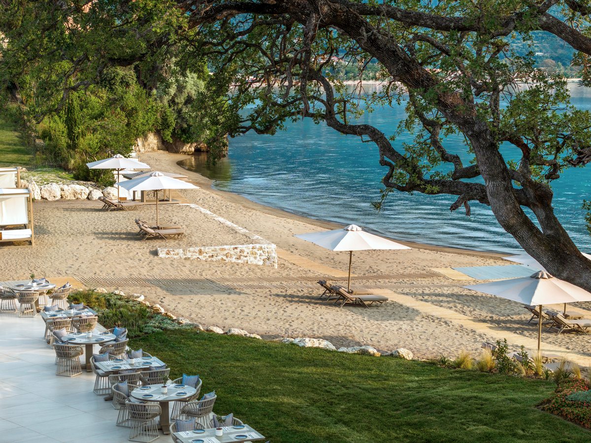 Sunbeds and parasols on the sand with matting walkways across the beach, the water a few metres away.