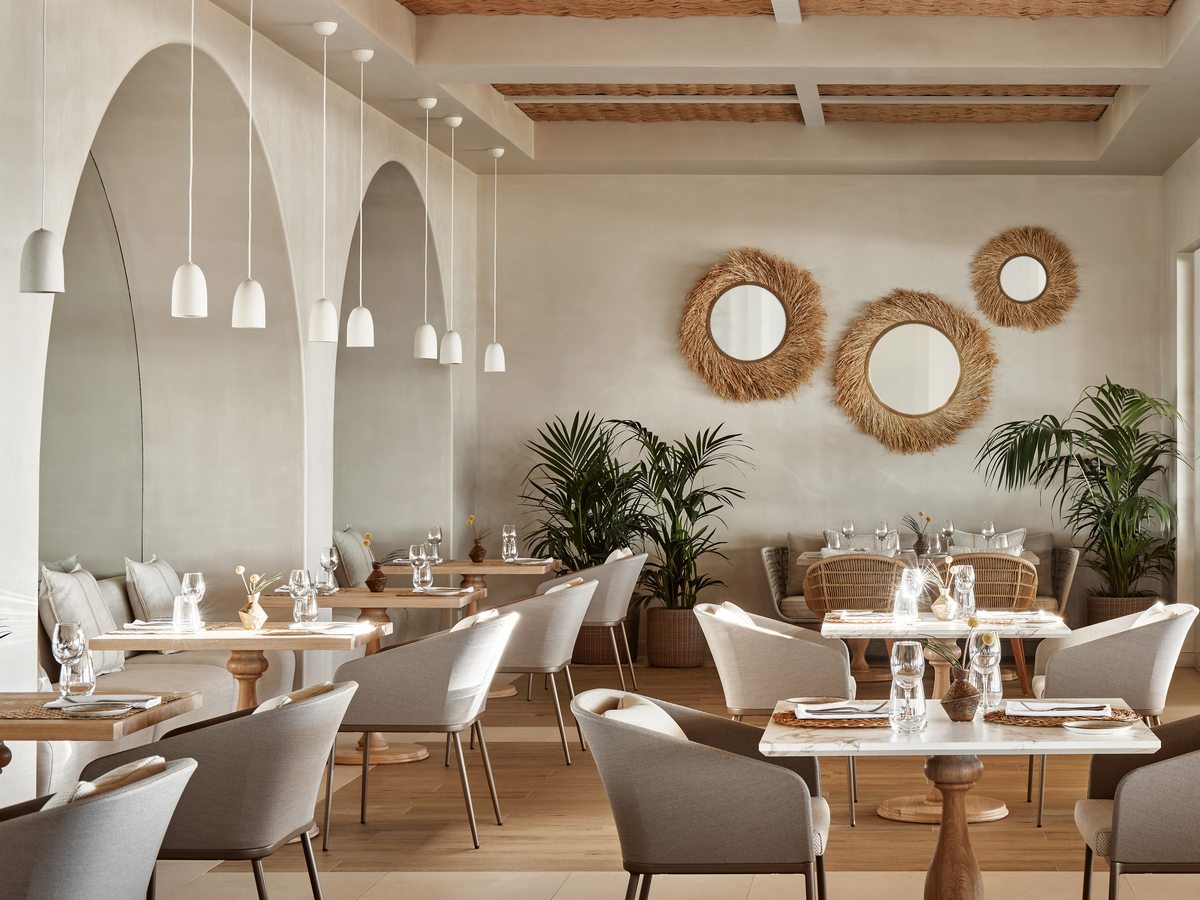 The dining room at Fresco, with tall arches, woven mirrors and hanging pendant lights.