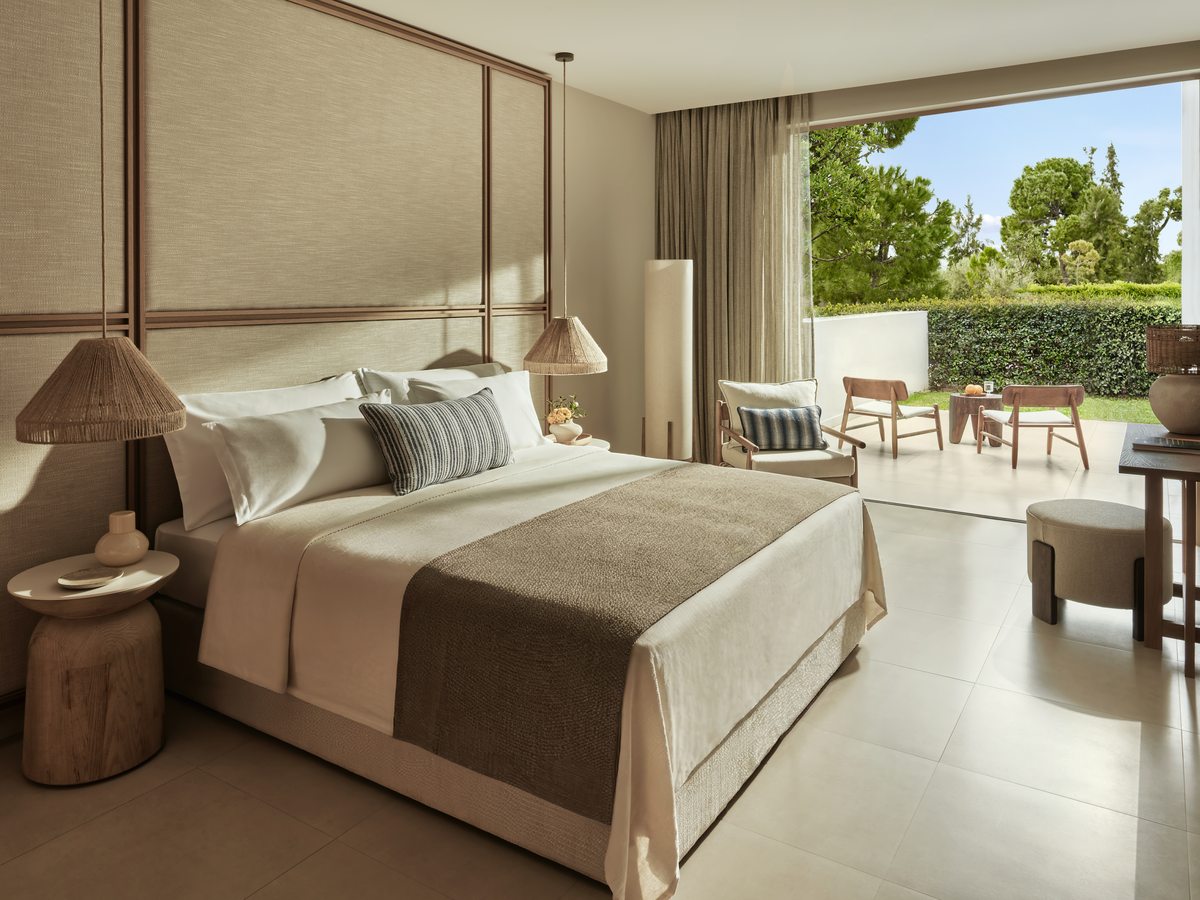A Double Bungalow with a double bed and glass doors opening onto a garden terrace.