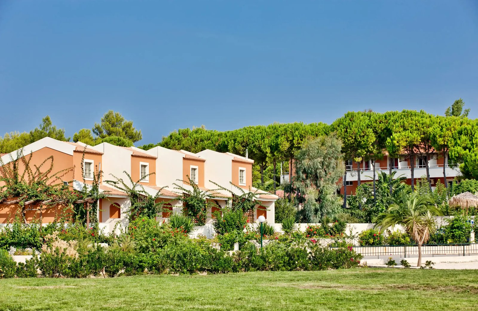 The Ionian Sea Hotel & Aqua Park at Kounopetra on Kefalonia: garden grounds and pools near the red-sand beach.