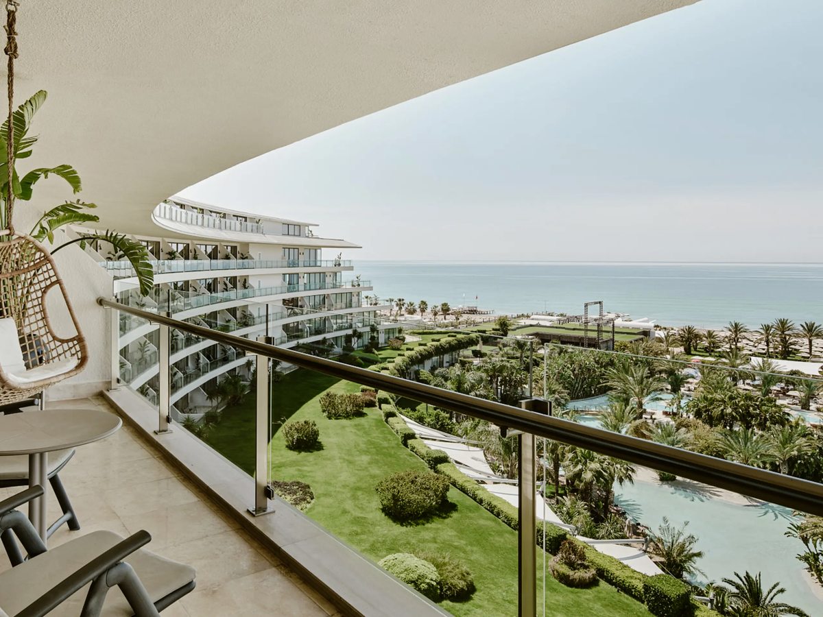 Lawns, clipped beds and long lagoon pools running from the curved resort building down to the beach and the sea.