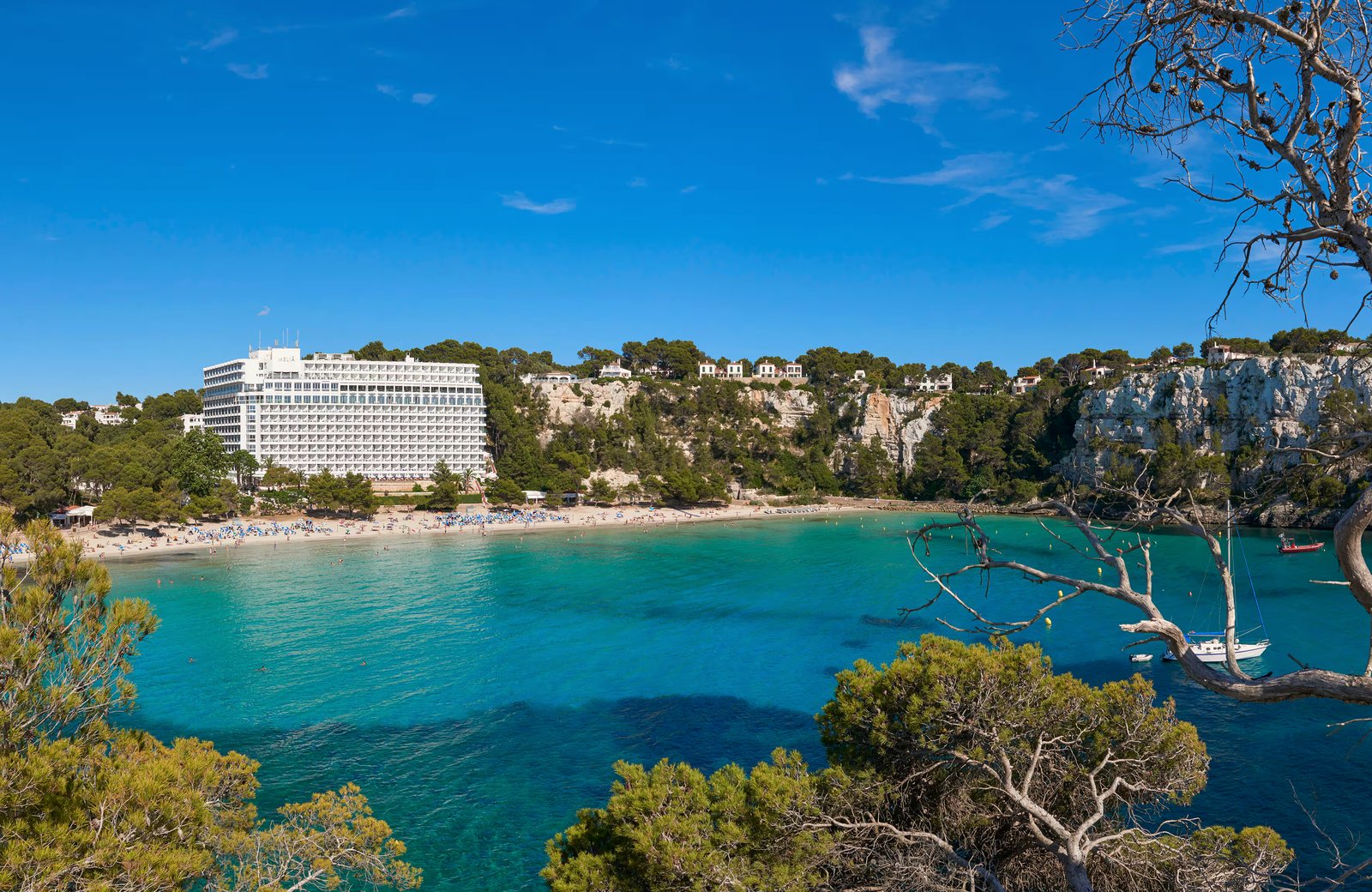 Meliá Cala Galdana on the beachfront of the Cala Galdana cove in Menorca, backed by pine-covered cliffs.