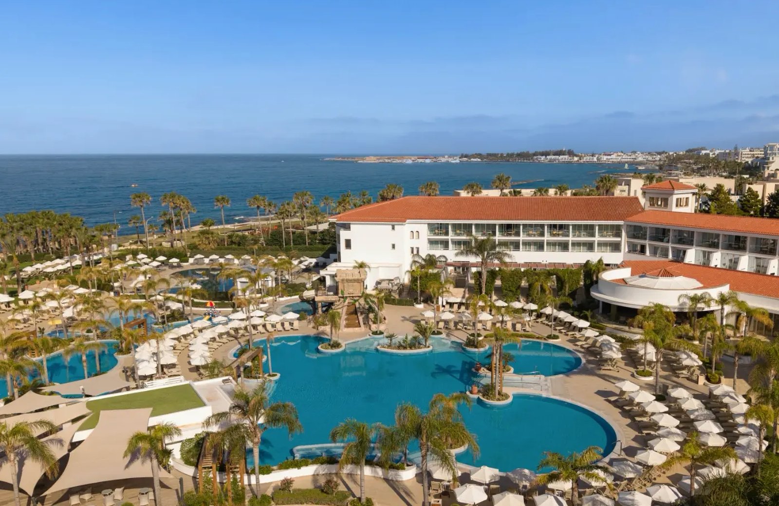 Olympic Lagoon Resort Paphos: lagoon pools threading through landscaped gardens down to the Paphos seafront.