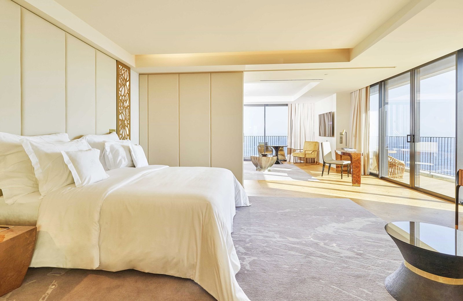 A suite bedroom at the Savoy Palace in cream and gold, opening through to a lounge and a balcony above the Atlantic.