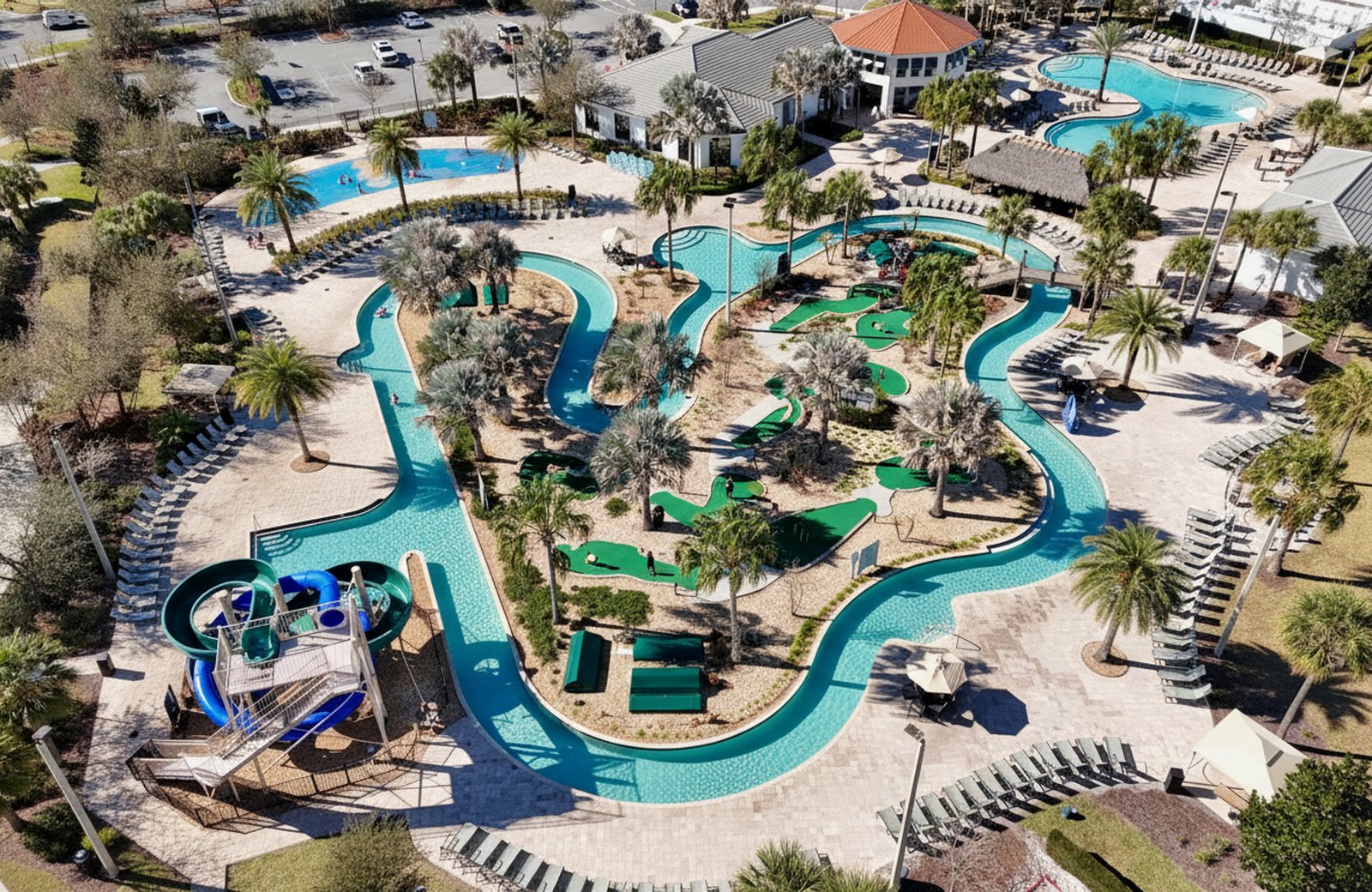 Storey Lake Resort: an aerial view of the Hideaway Club water park, with a zero-entry pool, lazy river, waterslides and a splash pad, backed by the resort's white apartment buildings and a lake.