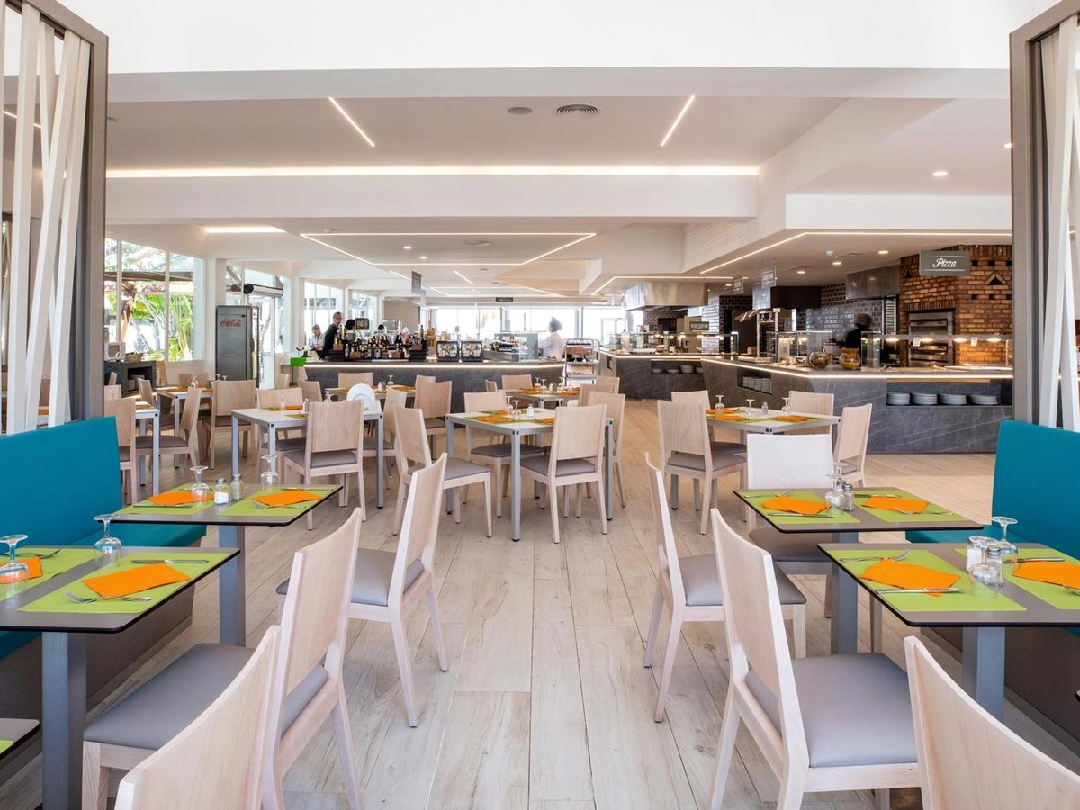 The buffet restaurant's dining room, with turquoise banquettes, pale wood chairs and colourful placemats on square tables.