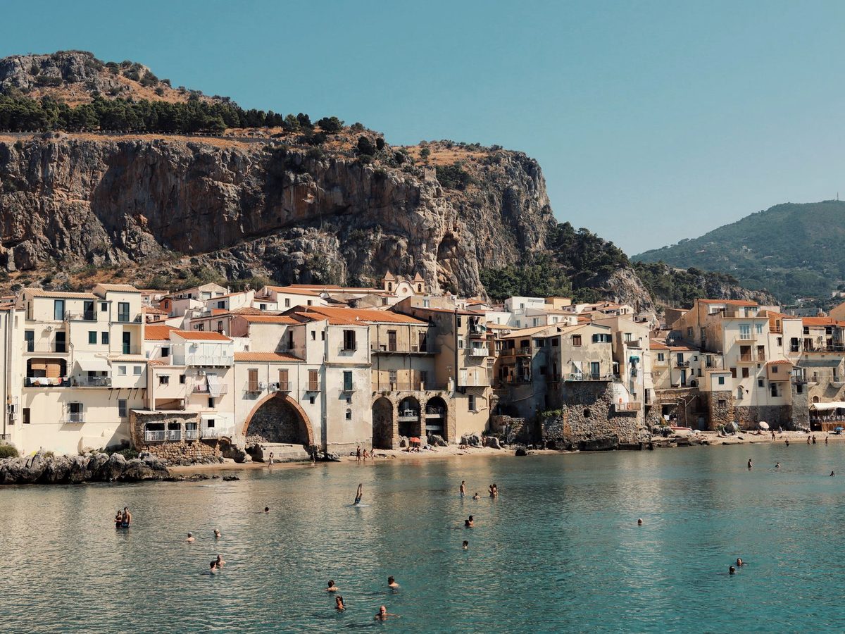 Swimmers in the clear shallows at Cefalù