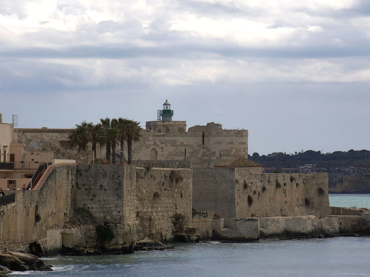 Ortigia's sea walls and lighthouse in Syracuse
