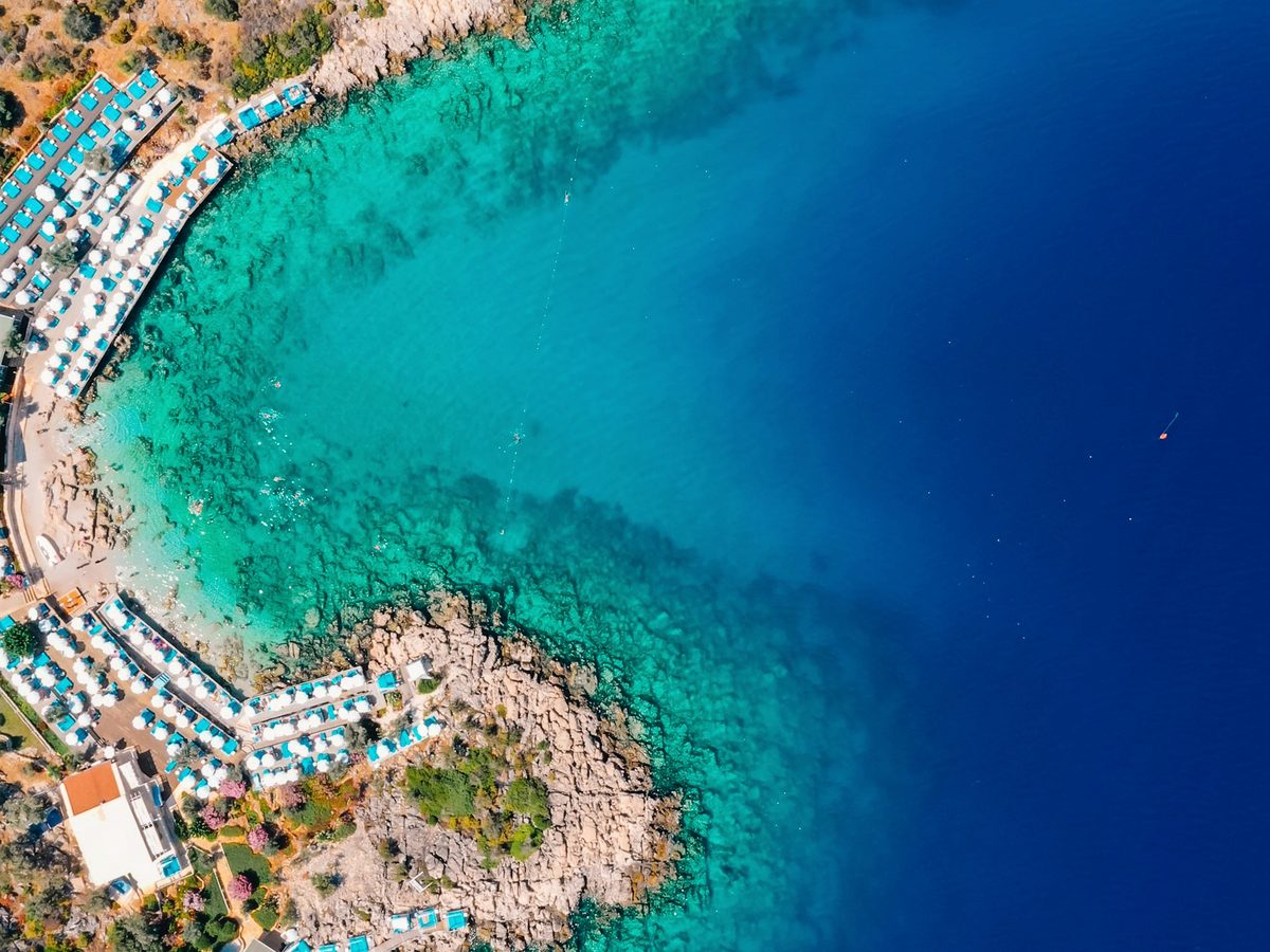 Beach-club platforms on a clear-water cove